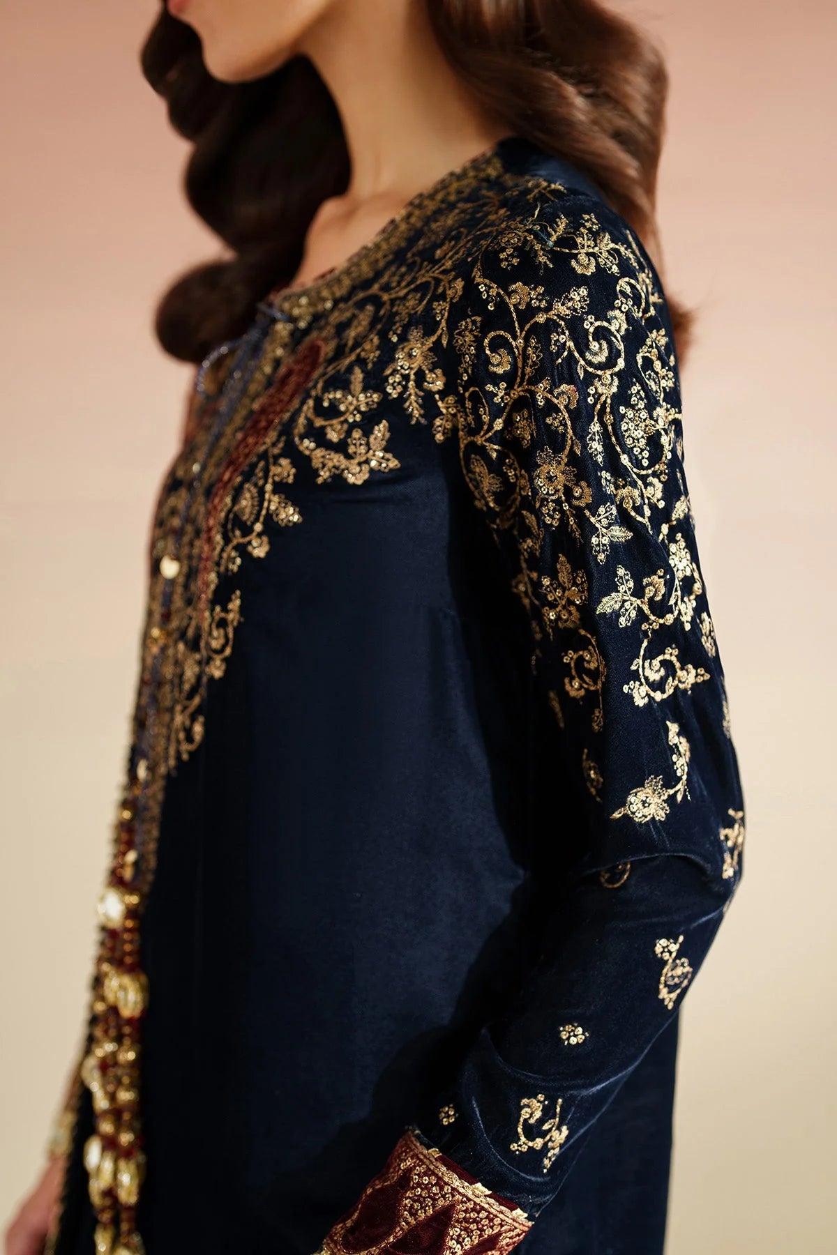 Navy blue outfit with gold embroidery on a beige background
