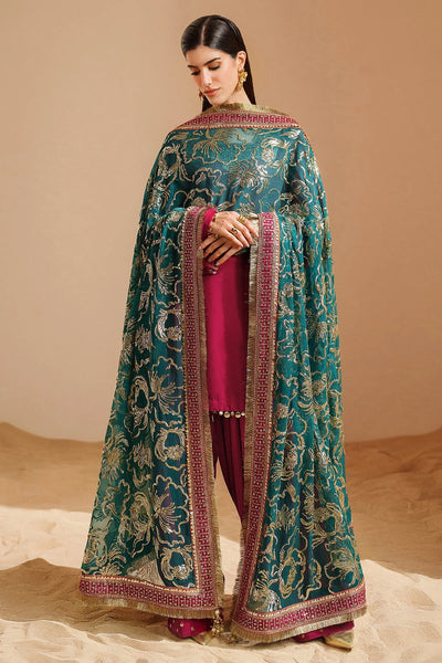 Woman wearing a traditional pink velvet kurta salwar outfit with green dupatta against a beige backgroundWoman wearing a traditional pink velvet kurta salwar outfit with green dupatta against a beige background
