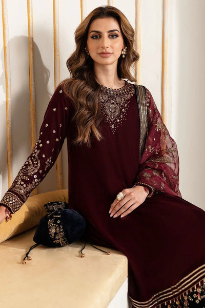 Woman in traditional maroon and navy velvet salwar suit outfit with a matching dupatta in a minimalistic setting.Woman in traditional maroon and navy velvet salwar suit outfit with a matching dupatta in a minimalistic setting.