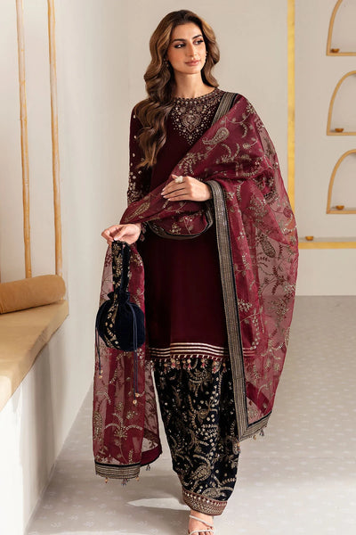 Woman in traditional maroon and navy velvet salwar suit outfit with a matching dupatta in a minimalistic setting.Woman in traditional maroon and navy velvet salwar suit outfit with a matching dupatta in a minimalistic setting.