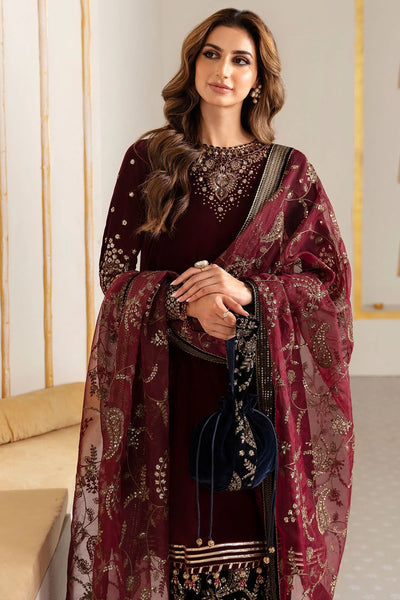 Woman in traditional maroon and navy velvet salwar suit outfit with a matching dupatta in a minimalistic setting.Woman in traditional maroon and navy velvet salwar suit outfit with a matching dupatta in a minimalistic setting.