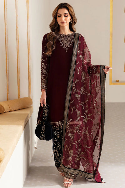 Woman in traditional maroon and navy velvet salwar suit outfit with a matching dupatta in a minimalistic setting.Woman in traditional maroon and navy velvet salwar suit outfit with a matching dupatta in a minimalistic setting.