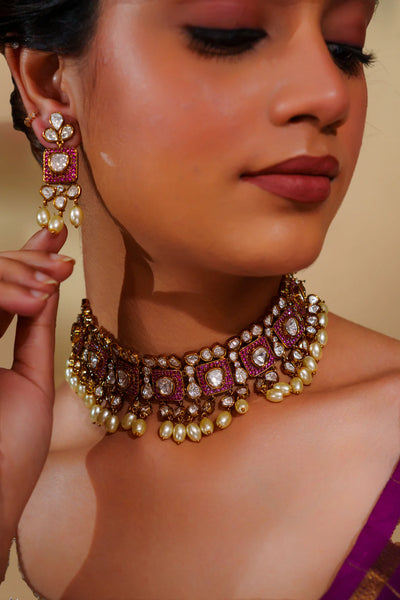 Close-up of a woman wearing a decorative necklace and earrings on a beige backgroundClose-up of a woman wearing a decorative necklace and earrings on a beige background