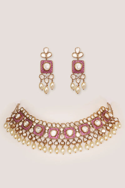 Kundan Polki Necklace and earrings set with pink gemstones on a light pink backgroundKundan Polki Necklace and earrings set with pink gemstones on a light pink background