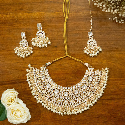 Bridal Kundan Jewelry set, earrings, and yellow flowers on a wooden surfaceBridal Kundan Jewelry set, earrings, and yellow flowers on a wooden surface