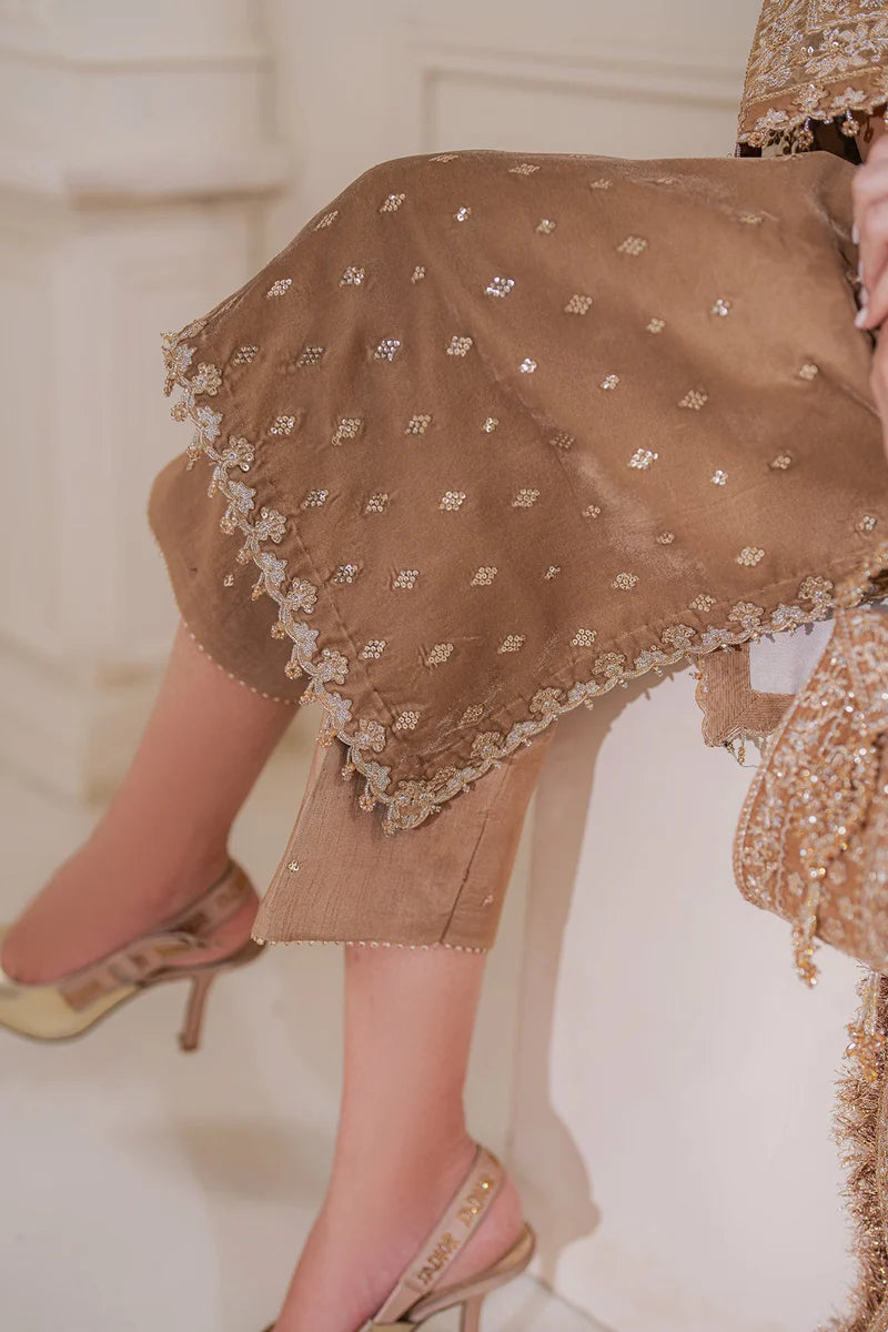 Woman wearing a beige velvet salwar suit embroidered outfit in a minimalistic setting