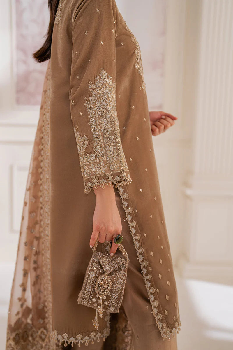 Woman wearing a beige velvet salwar suit embroidered outfit in a minimalistic setting