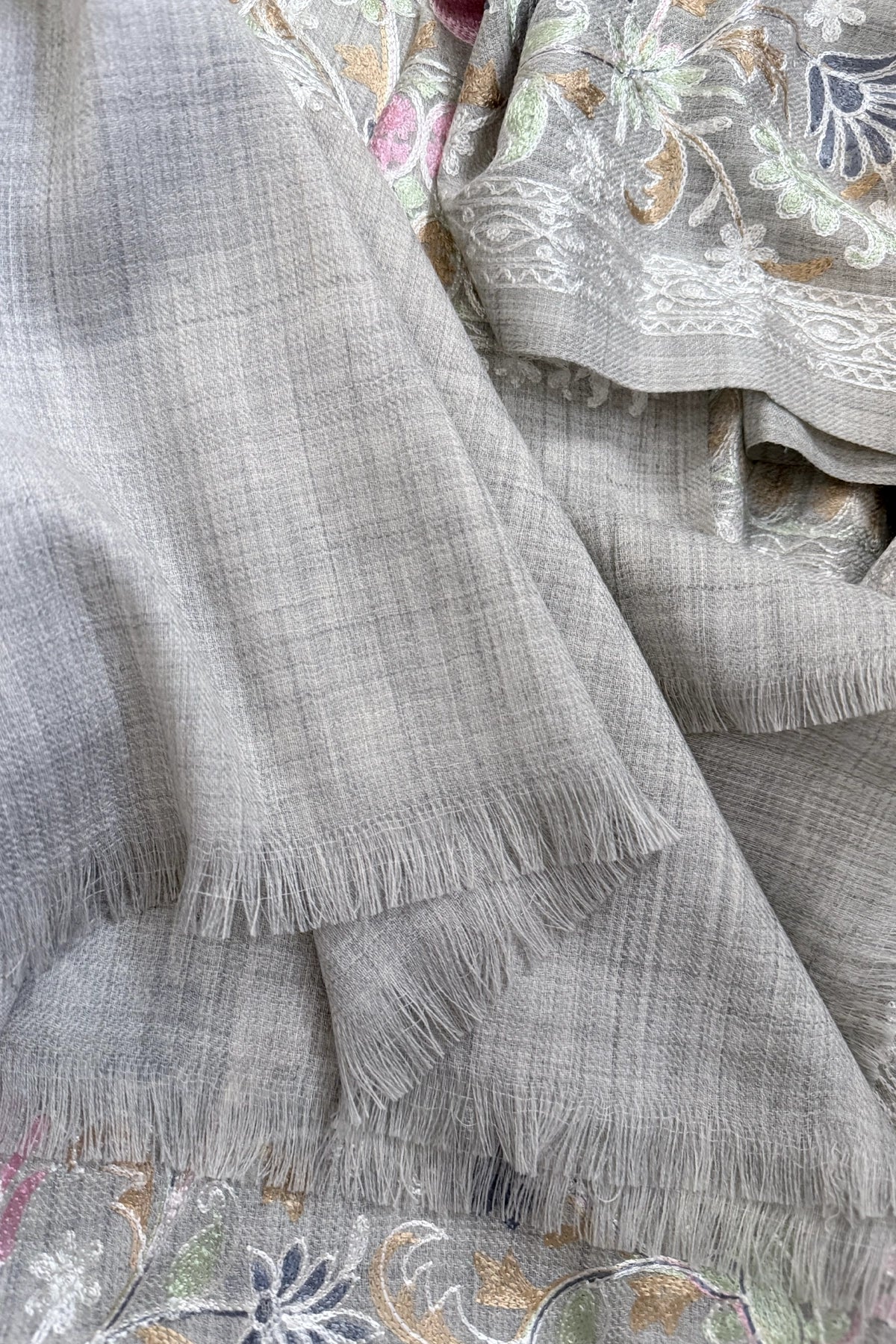 Embroidered shawl with floral kashmiri work on a gray background