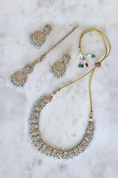 Jewelry set with necklace, earrings, and tikka hairpin on a marble surfaceJewelry set with necklace, earrings, and tikka hairpin on a marble surface