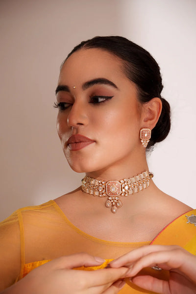 Woman wearing a Peach Pink Kundan Choker Set with a plain backgroundWoman wearing a Peach Pink Kundan Choker Set with a plain background