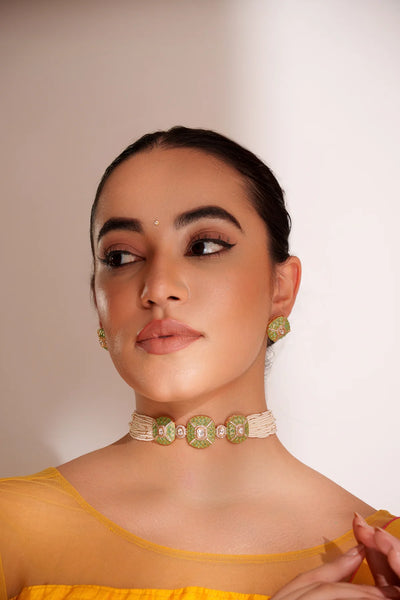 Woman wearing a yellow top and Gold Finish Green Stones Kundan Polki Necklace And Earring SetWoman wearing a yellow top and Gold Finish Green Stones Kundan Polki Necklace And Earring Set
