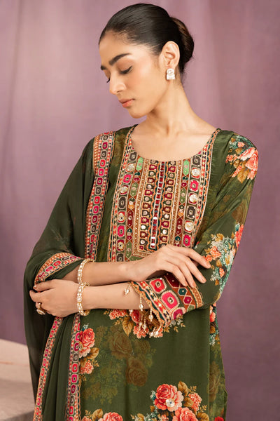 Woman wearing a green embroidered traditional outfit with a pink backgroundWoman wearing a green embroidered traditional outfit with a pink background