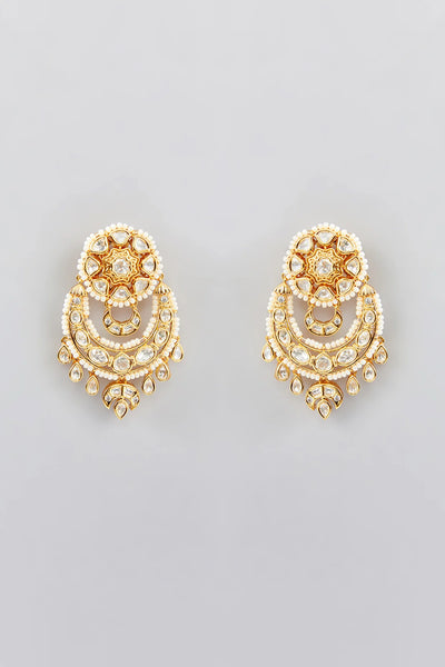 Pair of gold kundan earrings with intricate designs on a light gray backgroundPair of gold kundan earrings with intricate designs on a light gray background