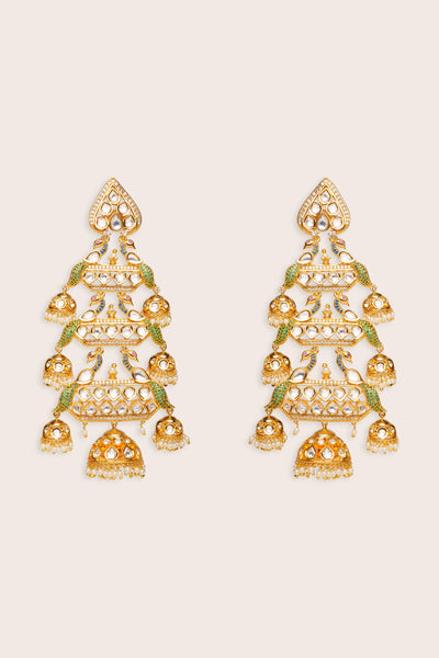 Pair of gold and green kundan earrings on a beige backgroundPair of gold and green kundan earrings on a beige background