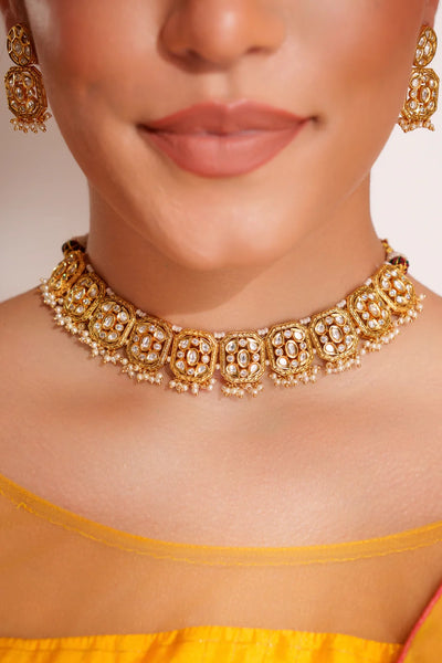 Close-up of a women wearing a traditional gold kundan & pearl jewelry necklace and earringsClose-up of a women wearing a traditional gold kundan & pearl jewelry necklace and earrings