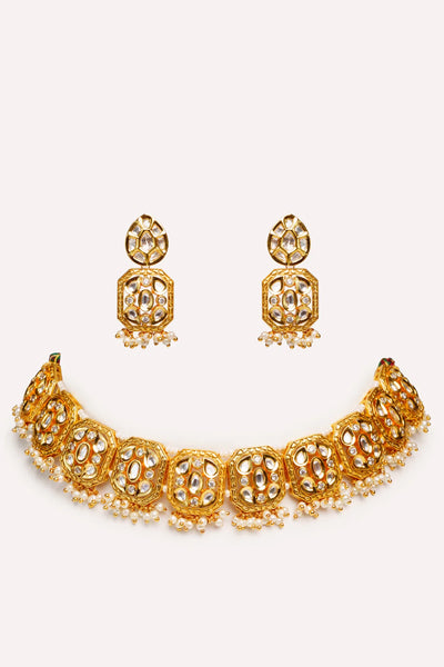 Traditional gold kundan & pearl jewelry Gold necklace and earrings set on a white backgroundTraditional gold kundan & pearl jewelry Gold necklace and earrings set on a white background