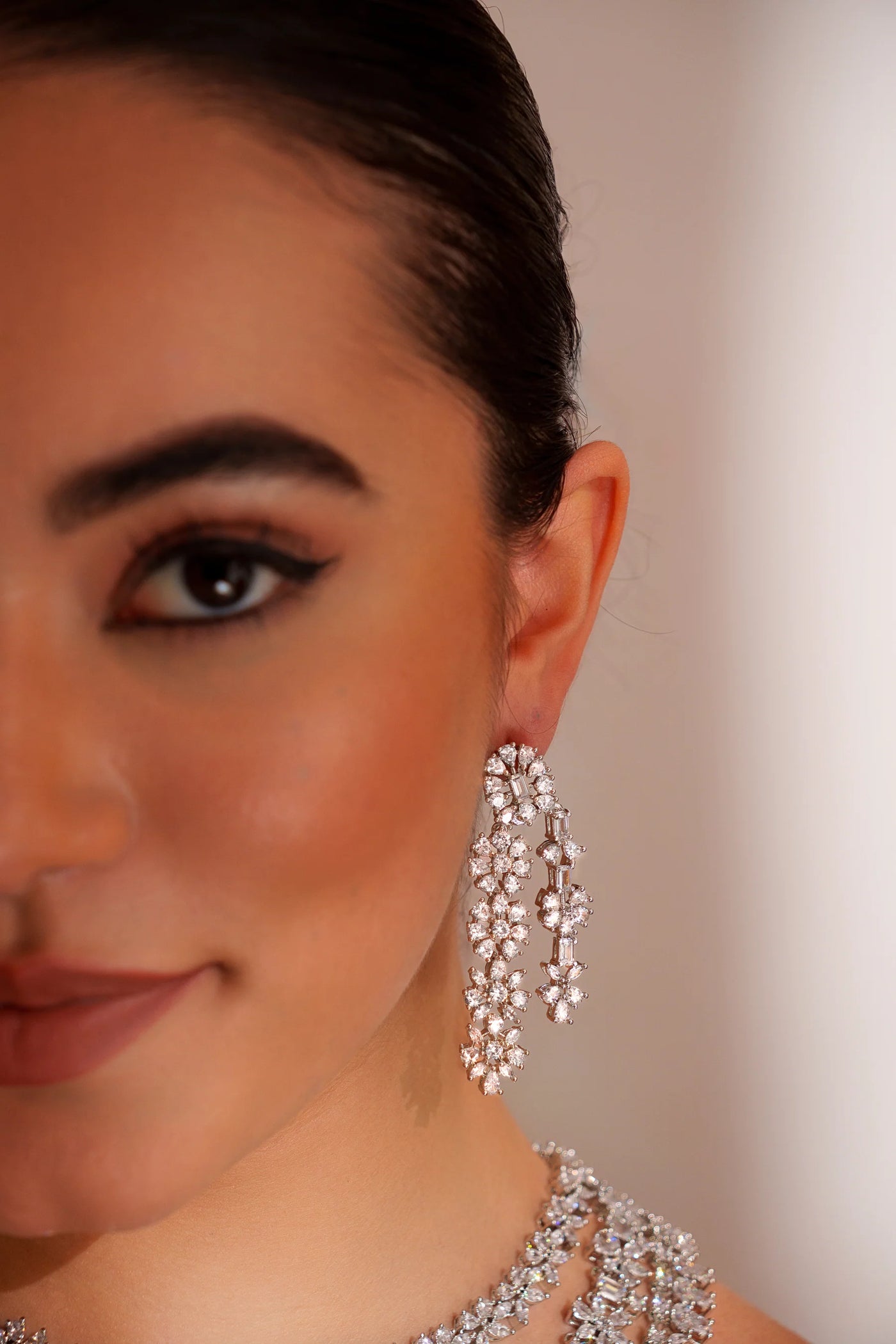 Close-up of a woman wearing sparkling silver earrings with a blurred background