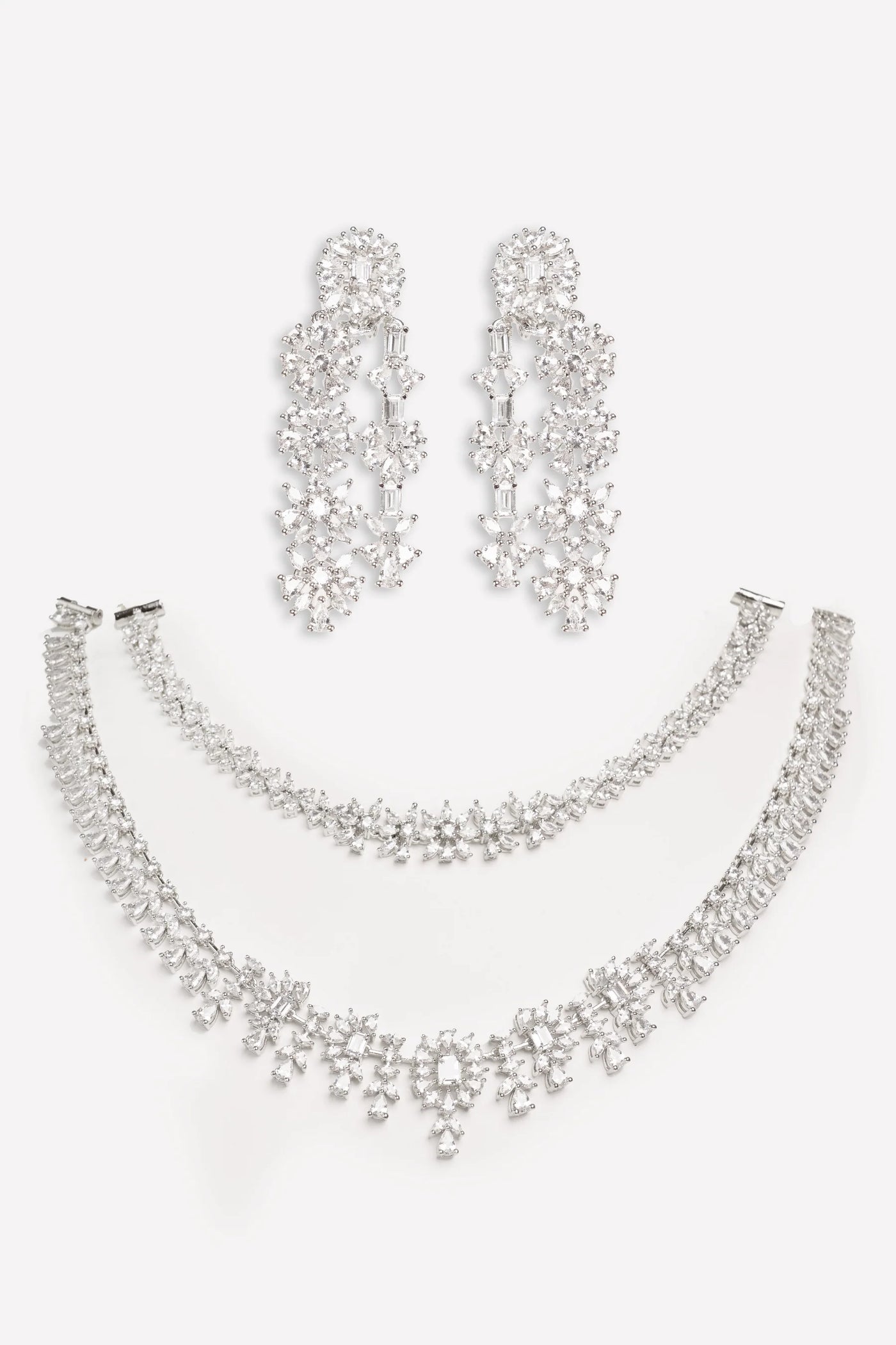 Silver jewelry set with necklace, bracelet, and earrings on a white background