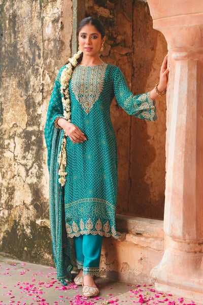 Woman in a teal blue traditional outfit standing in front of an old stone wall.Woman in a teal blue traditional outfit standing in front of an old stone wall.