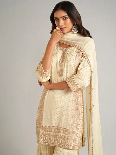 Woman wearing a cream-colored embroidered traditional outfit on a gray backgroundWoman wearing a cream-colored embroidered traditional outfit on a gray background