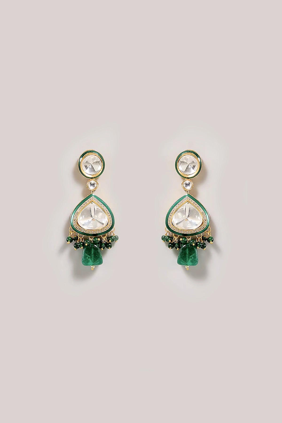 Pair of Kundan Polki green teardrop earrings with gemstone-like elements on a light gray background
