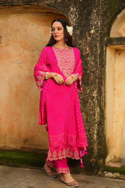 Woman in a pink traditional outfit standing against an old architectural wall.Woman in a pink traditional outfit standing against an old architectural wall.