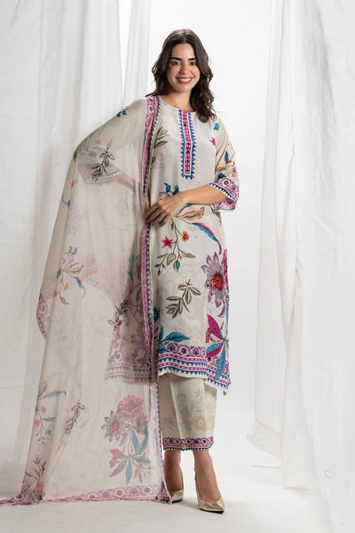 Woman wearing a floral embroidered outfit with a matching dupatta against a white background