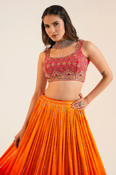 Woman wearing a red blouse with intricate patterns and an orange skirt against a beige backgroundWoman wearing a red blouse with intricate patterns and an orange skirt against a beige background