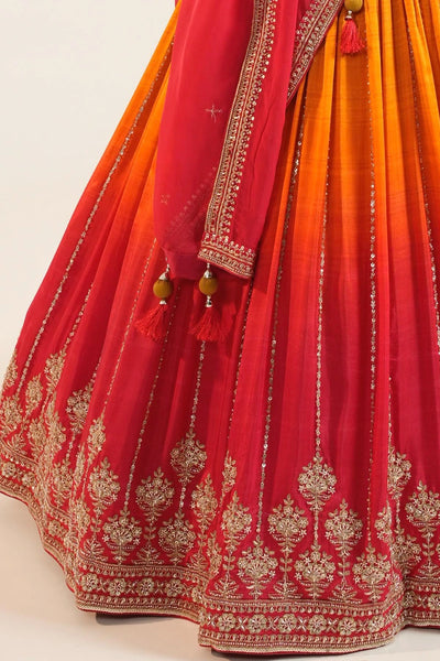 Red and orange traditional lehenga set with intricate patterns on a white backgroundRed and orange traditional lehenga set with intricate patterns on a white background