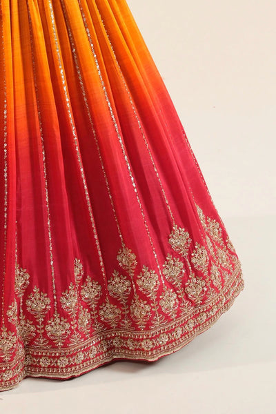 Gradient fabric with orange to red color scheme and intricate white embroidery on a white backgroundGradient fabric with orange to red color scheme and intricate white embroidery on a white background