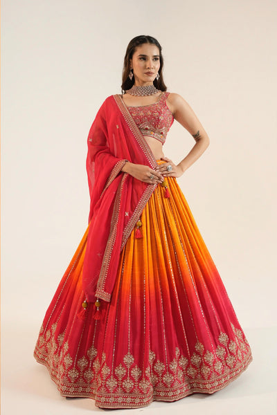 Woman wearing a red and orange traditional lehenga choli outfit Woman wearing a red and orange traditional lehenga choli outfit 