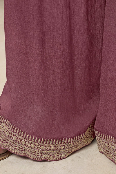 Close-up of a mauve fabric with gold embroidery on a neutral backgroundClose-up of a mauve fabric with gold embroidery on a neutral background