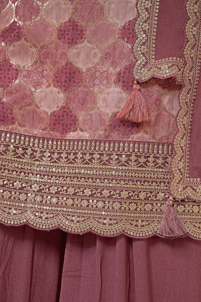 Close-up of a mauve embroidered fabric with gold detailing and tassels.Close-up of a mauve embroidered fabric with gold detailing and tassels.