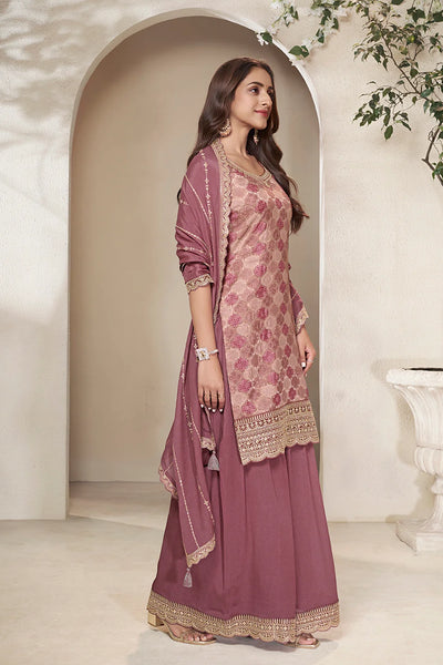 Woman in a traditional sharara outfit with a pink and gold patterned dupatta Woman in a traditional sharara outfit with a pink and gold patterned dupatta 