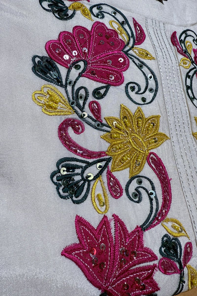Close-up of embroidered fabric with flowers and butterflies on a white backgroundClose-up of embroidered fabric with flowers and butterflies on a white background