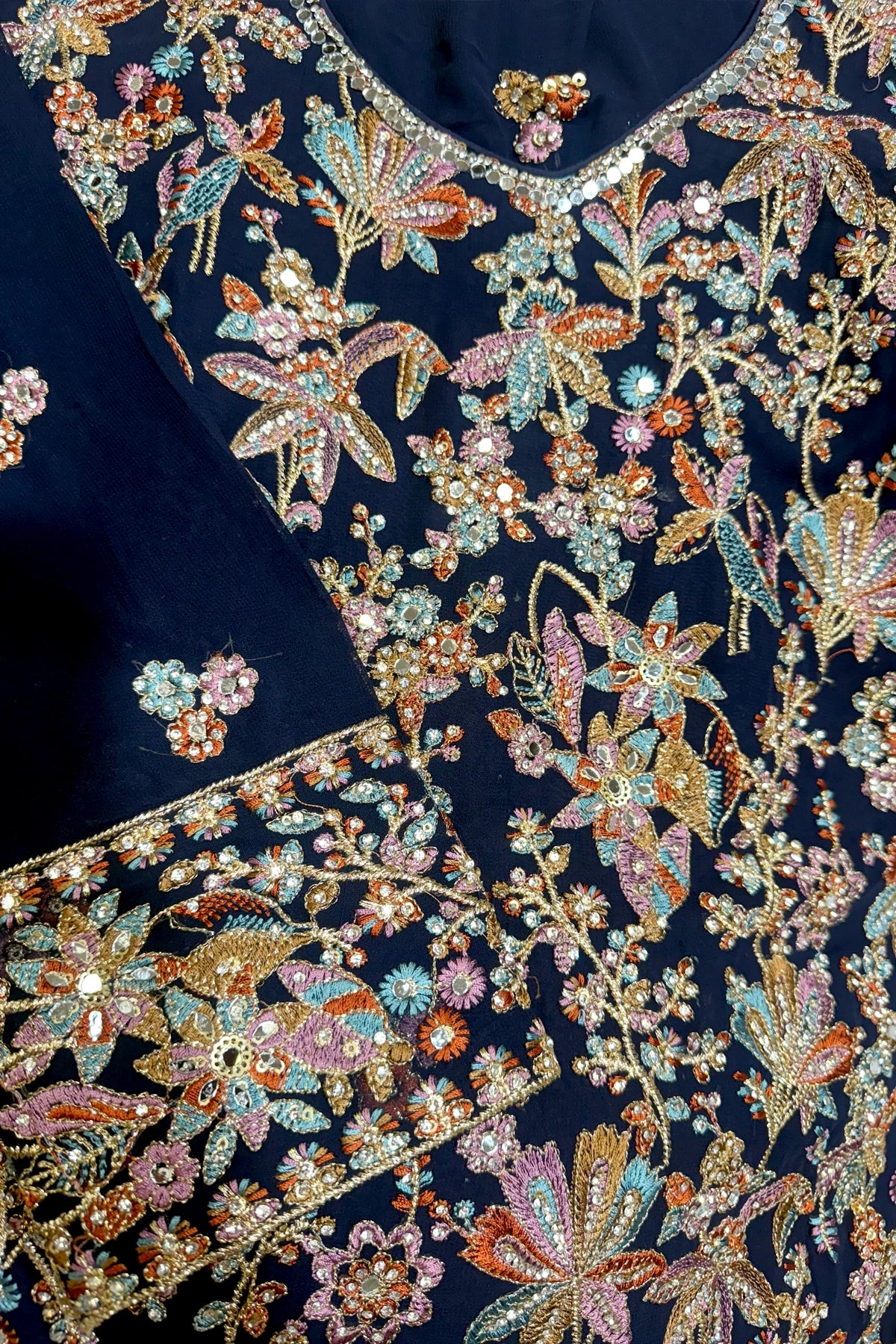Navy blue kurta set with intricate floral and butterfly embroidery in gold, pink, and blue.