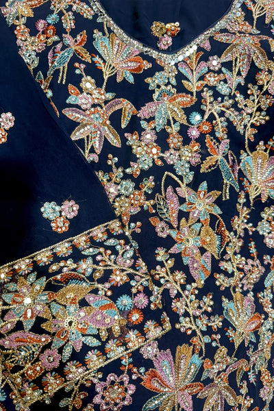 Navy blue kurta set with intricate floral and butterfly embroidery in gold, pink, and blue.Navy blue kurta set with intricate floral and butterfly embroidery in gold, pink, and blue.