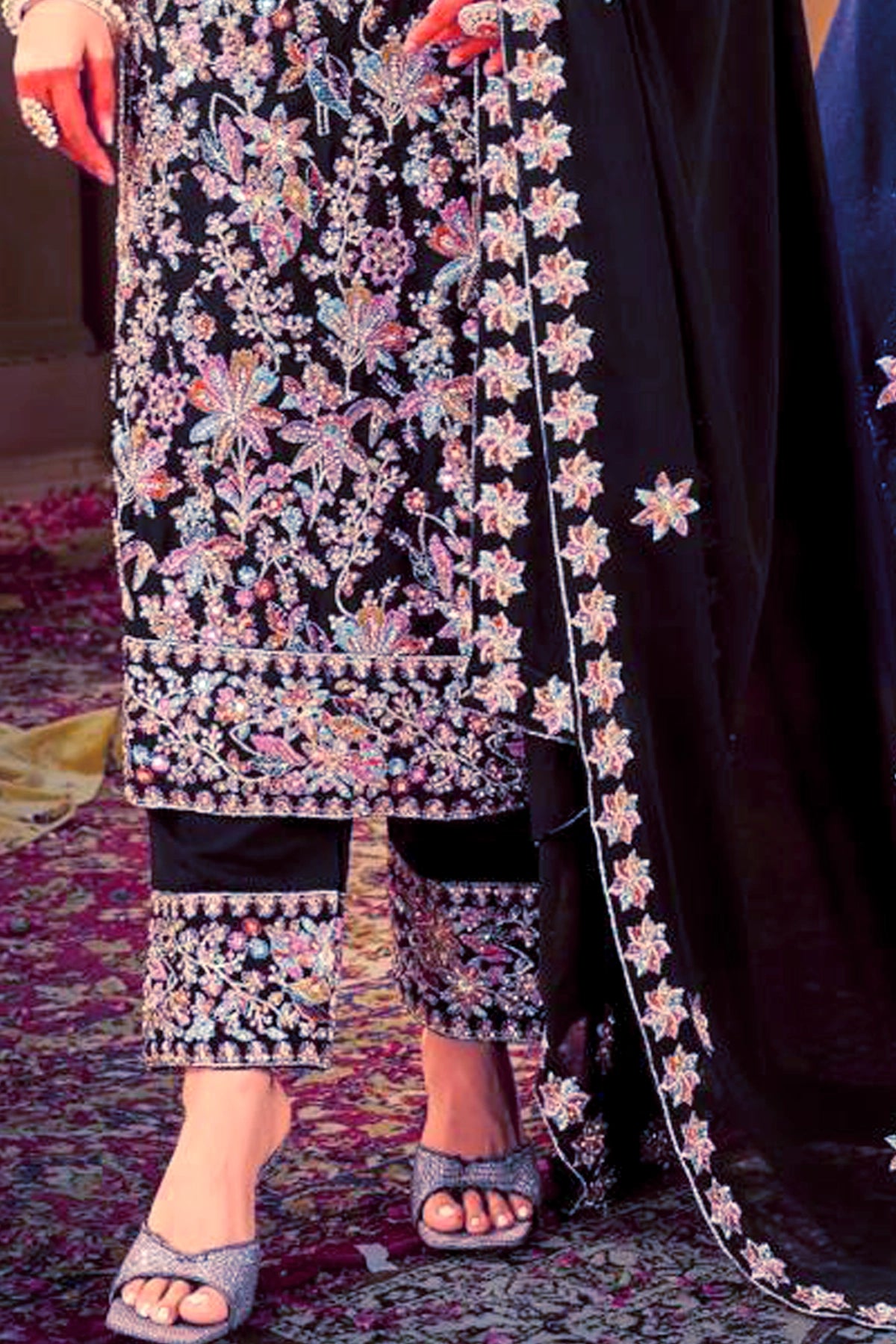 Traditional embroidered outfit with floral patterns on a dark background