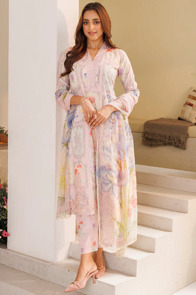 Woman in a floral pink kurta set standing on a staircase