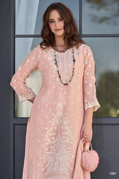 Woman wearing a pink embroidered kurta set with a blurred outdoor backgroundWoman wearing a pink embroidered kurta set with a blurred outdoor background