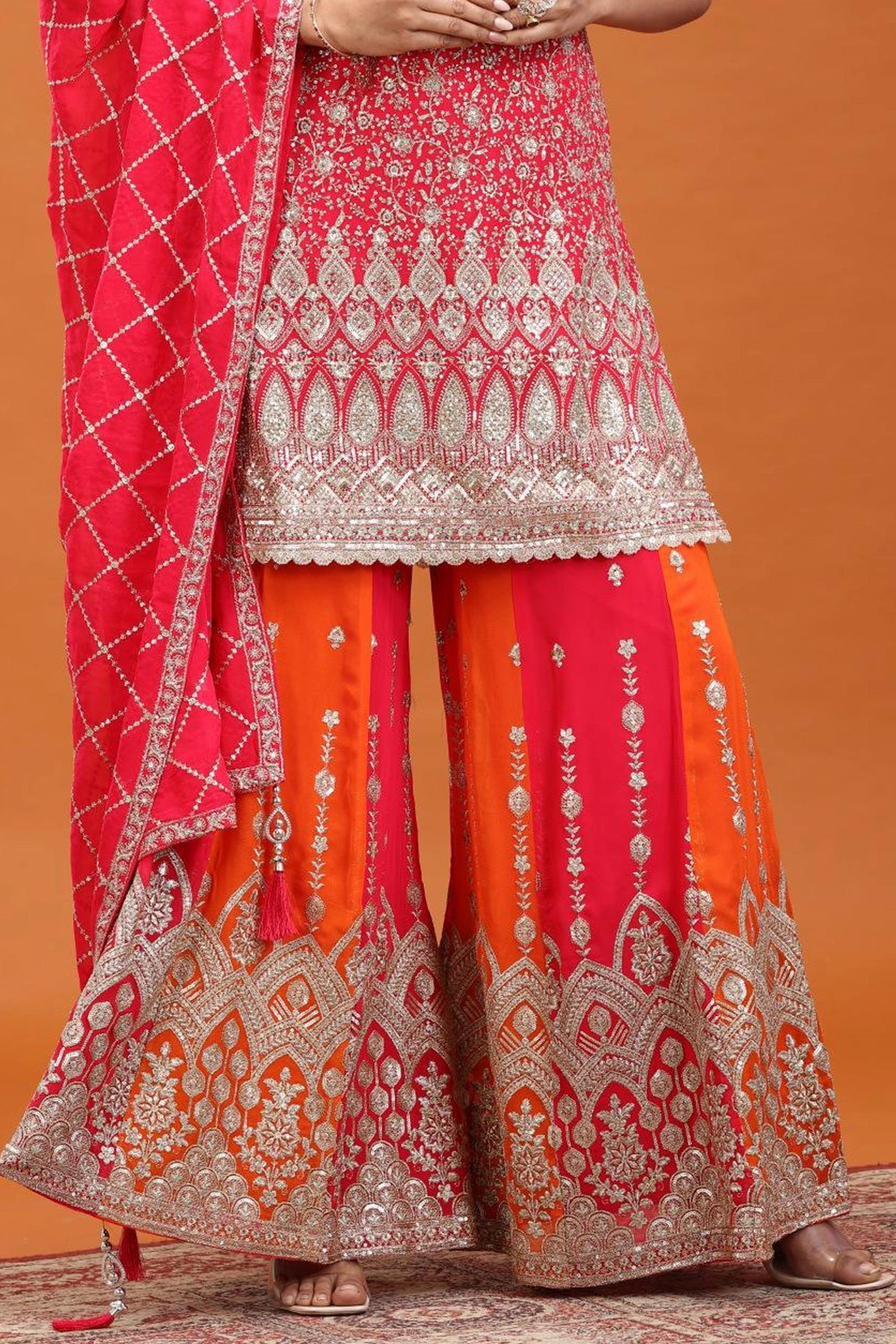 Traditional outfit with pink and orange embroidered palazzo on an orange background