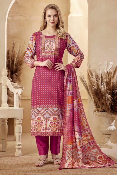 Woman wearing a pink embroidered traditional outfit with a matching dupatta in an elegant setting.