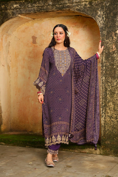 Woman in a traditional purple outfit standing against a textured wall.Woman in a traditional purple outfit standing against a textured wall.