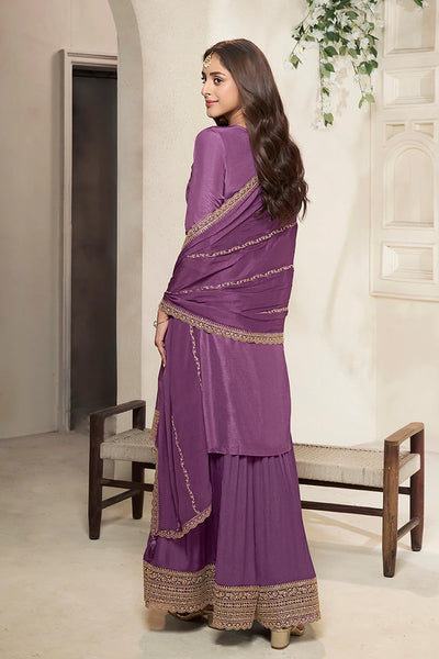 Woman wearing a purple sharara suit with gold border in an indoor settingWoman wearing a purple sharara suit with gold border in an indoor setting