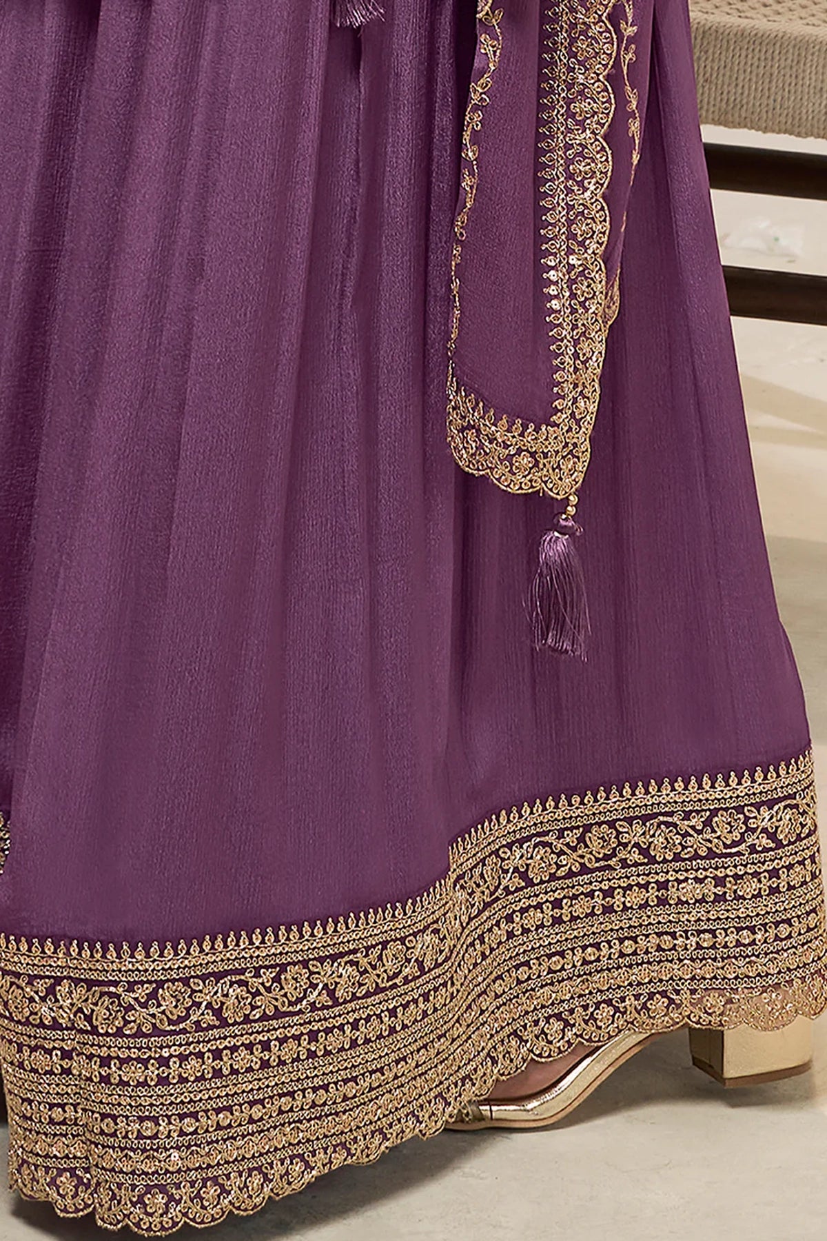 Purple sharara suit with gold embroidery on a neutral background