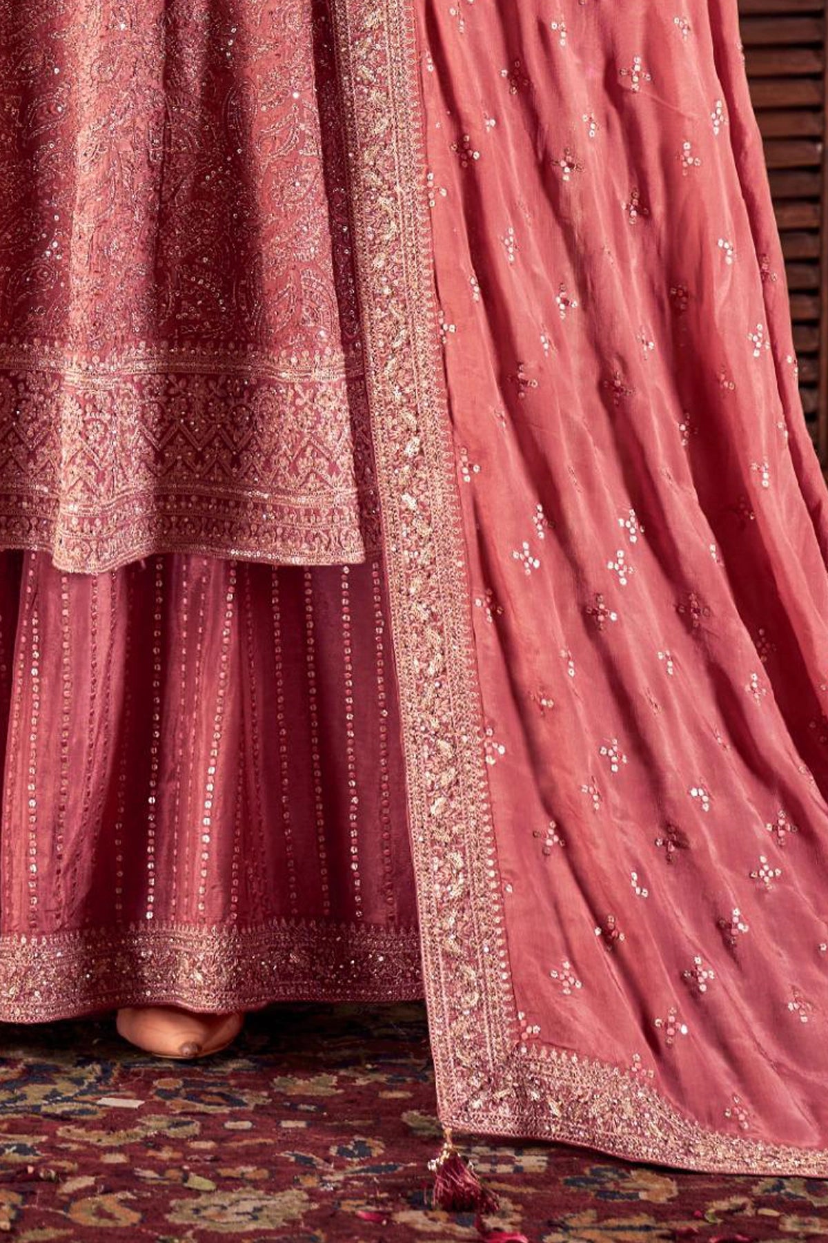 Close-up of a rose pink embroidered traditional outfit with intricate patterns.