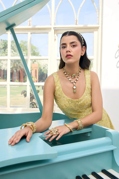 Woman in a Light Yellow Georgette Sharara Suit sitting on a blue piano with a window in the backgroundWoman in a Light Yellow Georgette Sharara Suit sitting on a blue piano with a window in the background